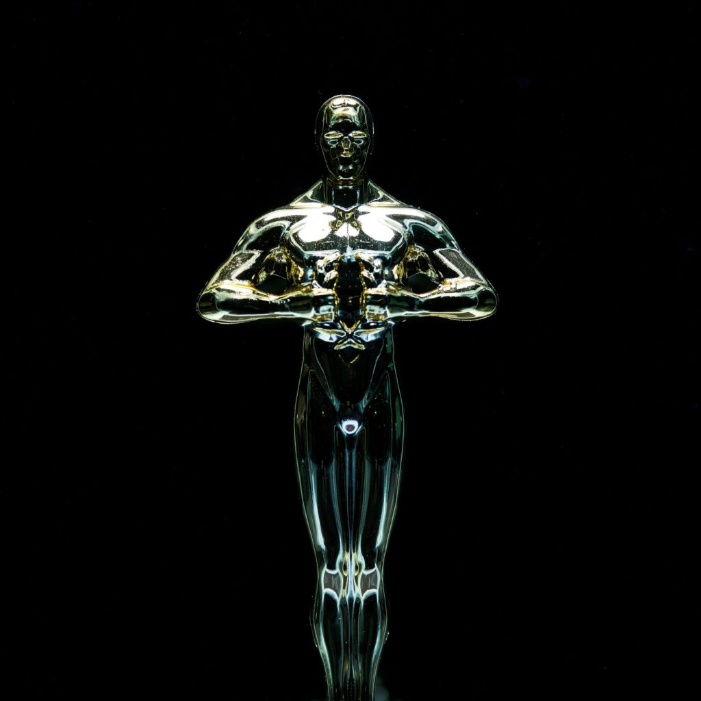 A golden trophy statue isolated on a black background symbolizing achievement and victory.